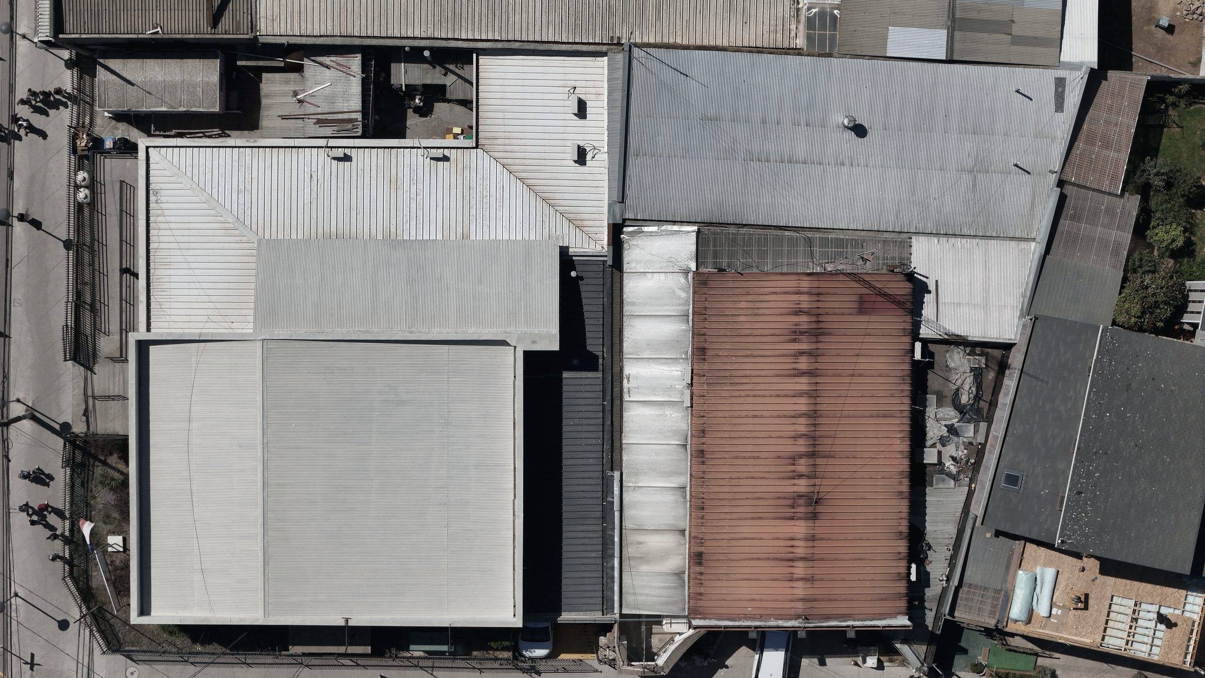 Top-down view of adjoining commercial roofs of metal and membrane