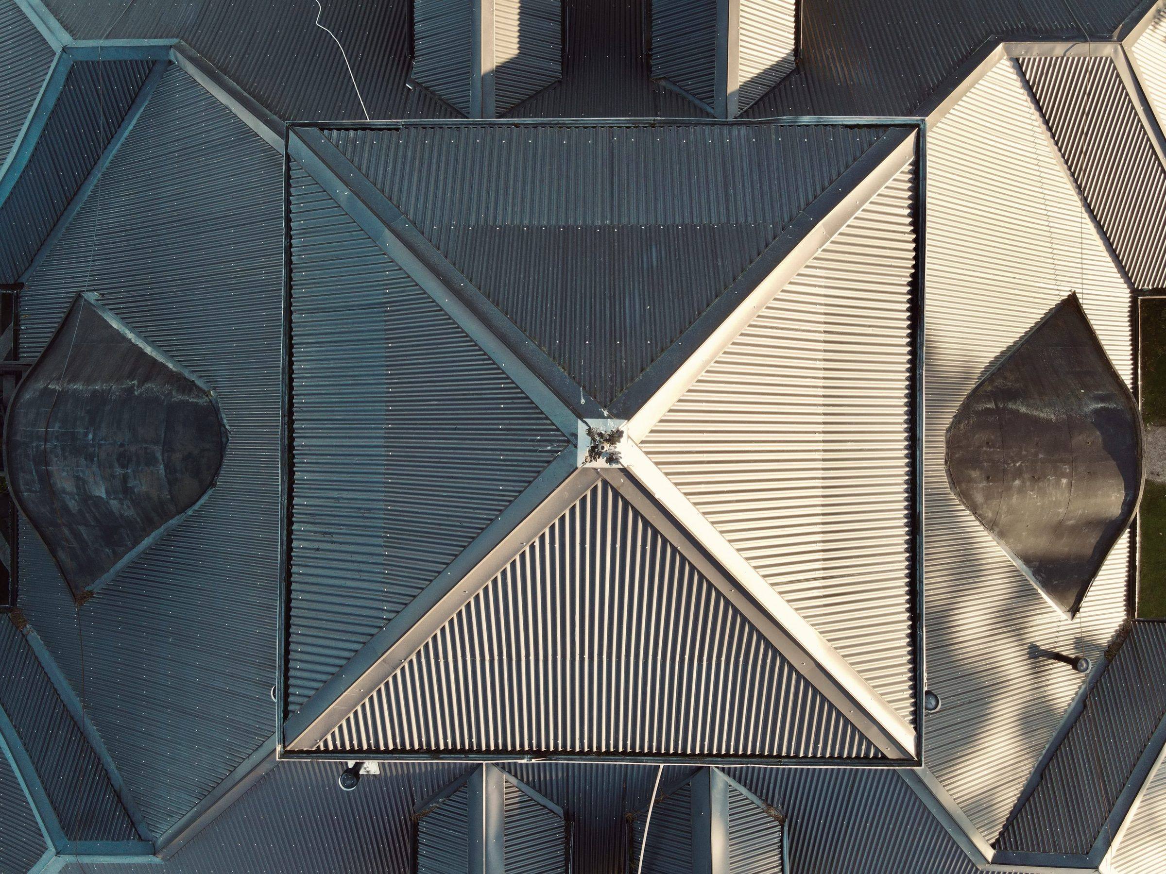 Top-down view of a corrugated metal hip roof, its hips meeting at a central peak
