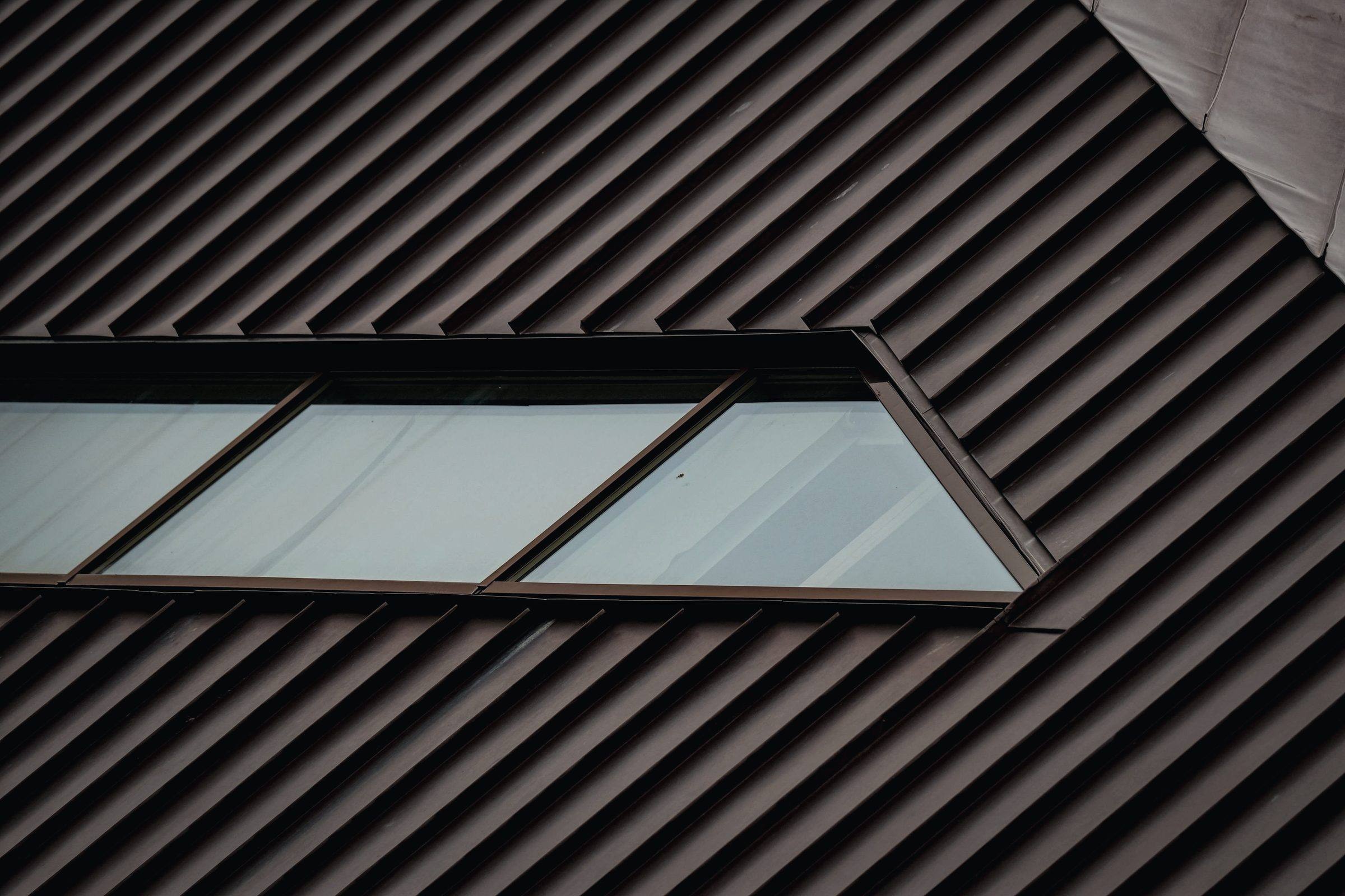 Standing-seam metal roof with flashing around a row of roof windows