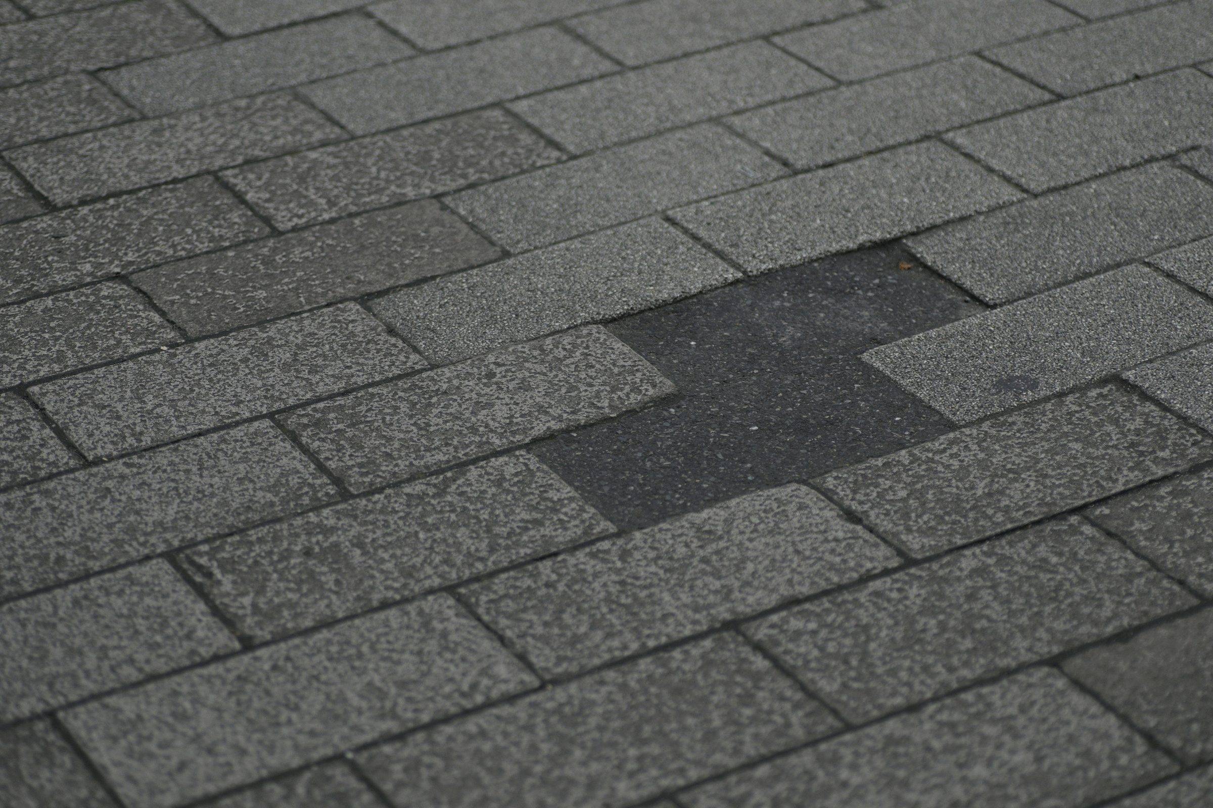 Asphalt shingle roof with a section of missing shingles